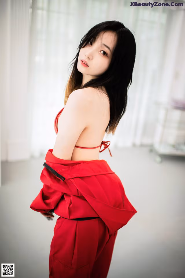 A woman in a red dress posing for a picture.