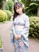 A woman in a blue kimono posing for a picture.