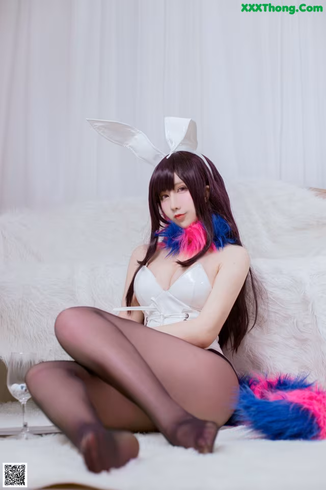 A woman in a bunny costume sitting on a white couch.