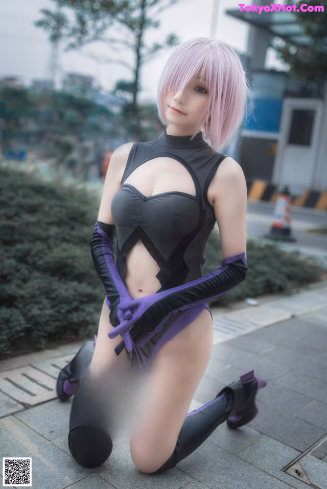 A woman in a black and purple outfit crouching down on the ground.