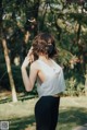 A woman wearing a face mask standing in a park.