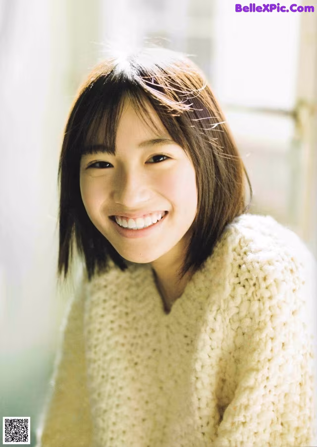 A woman in a white sweater smiles at the camera.