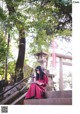 A woman in a red dress sitting on some steps.