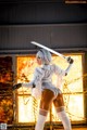 A woman in a white outfit holding a sword.