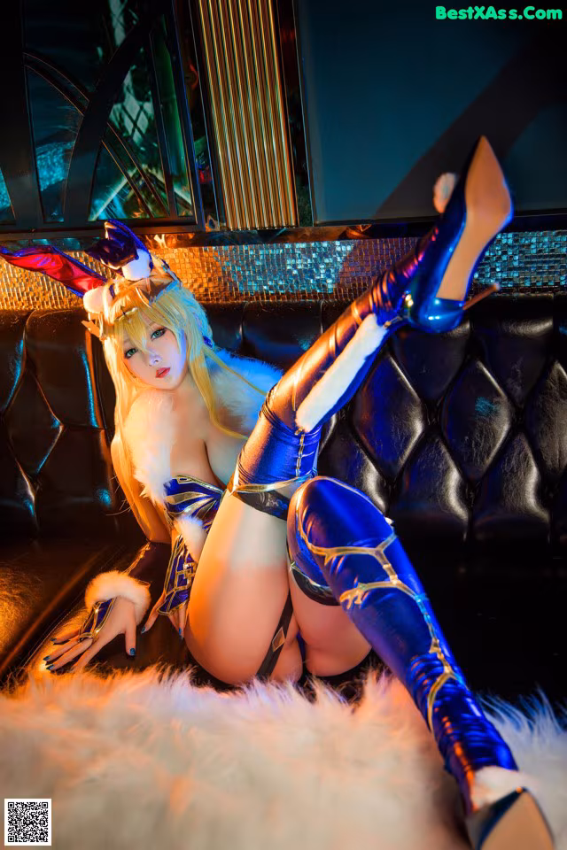 A woman in a blue and white outfit sitting on a couch.