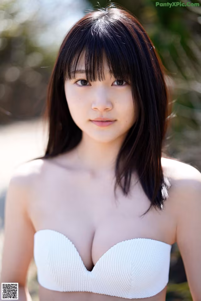 A woman in a white bikini posing for a picture.