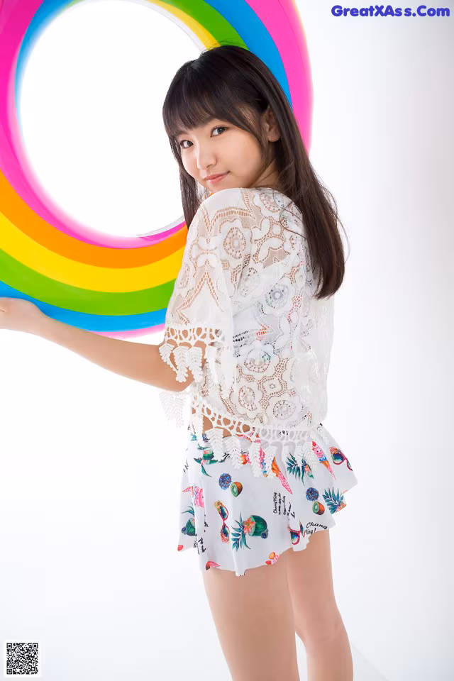 A young woman holding a rainbow in her hands.