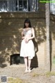 A woman standing in front of a brick building.