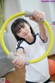 A young woman holding a hula hoop in her hands.